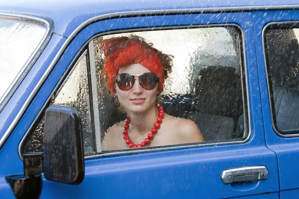 Ročník dívka řízení auta pod déšť — Stock fotografie