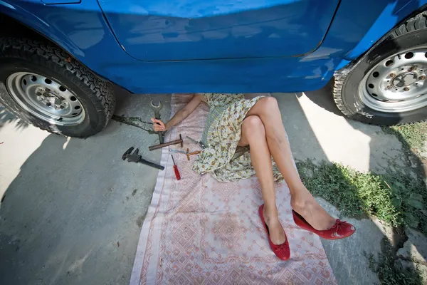 Ročník dívka s nástroji pod auto — Stock fotografie