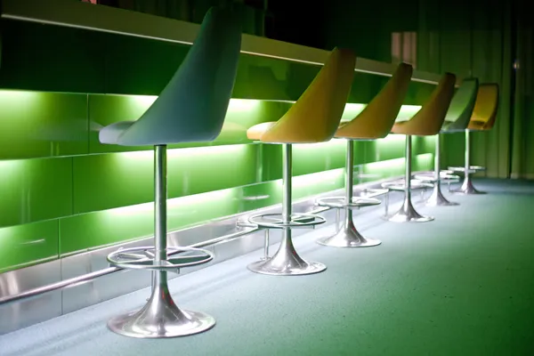 Cadeiras em fila com luzes verdes — Fotografia de Stock