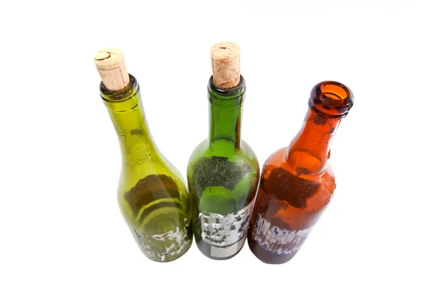 Três garrafas de vinho empoeiradas isoladas em branco — Fotografia de Stock