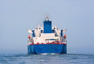 Aft of tanker sailing in the sea with water splashes from engine clipart