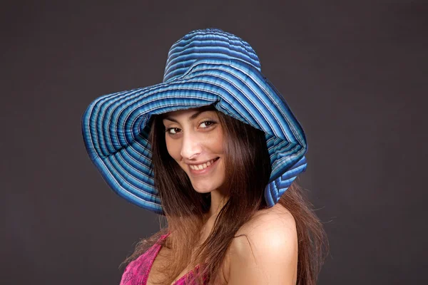 Bella giovane ragazza sorridente in cappello al buio — Foto Stock