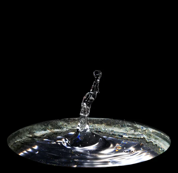 Água espirrar círculos wirh isolado no fundo preto — Fotografia de Stock