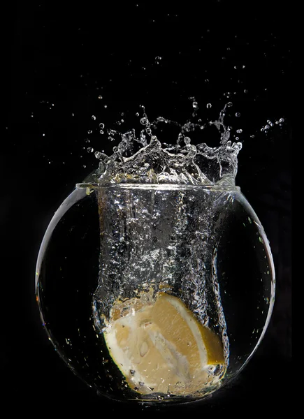 水の半分暗い背景にスプラッシュ イエロー レモン — ストック写真