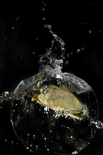 Зеленое яблоко наполовину в воде брызг — стоковое фото