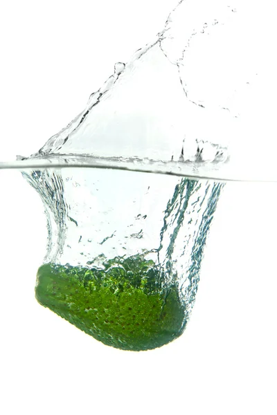 Zielony awokado w plusk wody na białym tle — Zdjęcie stockowe