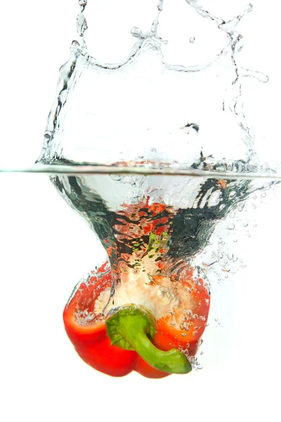 Páprica vermelha em respingo de água isolado no branco — Fotografia de Stock