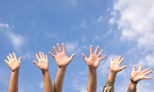 Les mains levées dans l'air à travers le ciel — Photo