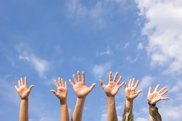 Hands rised up in air across sky — Stock Photo, Image