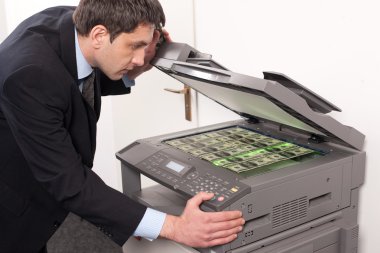 Businessman make false money on copy machine clipart
