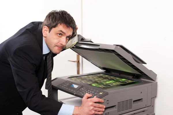 Affärsman gör falska pengar på kopieringsmaskin — Stockfoto