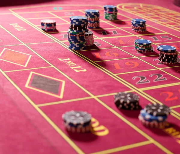 Gambling chips on red roulette table — Stock Photo, Image