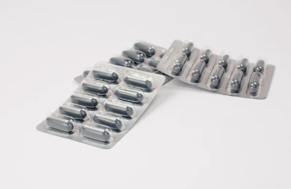Three blisters with grey pills on white — Stock Photo, Image