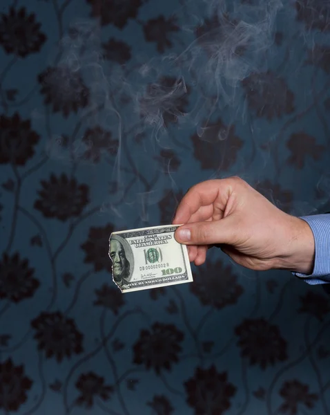 Smoking one hundred dollars bill in hand — Stock Photo, Image