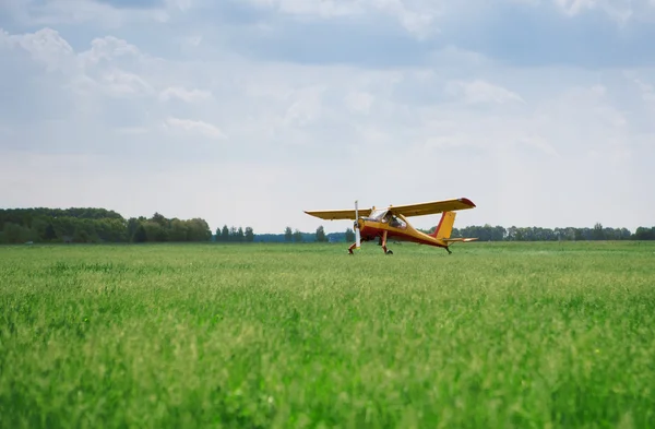 stock image Little yellow airplane on field