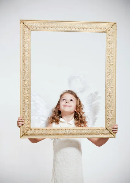 Menina com asas de anjo no quadro — Fotografia de Stock