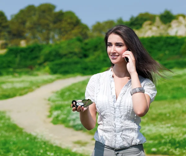Vakker kvinne som snakker i telefonen med kompass – stockfoto