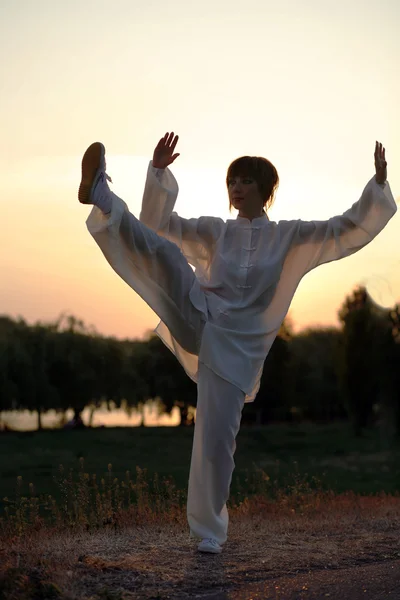 Kvinnan i vit kostym görs taiji chuan träningen — Stockfoto