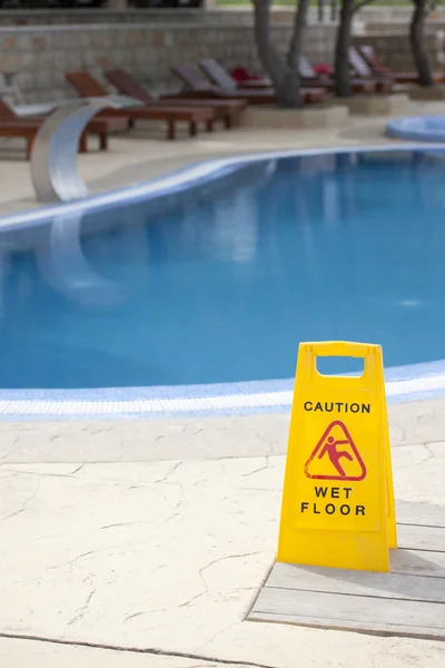 Caution wet floor near pool Royalty Free Stock Images