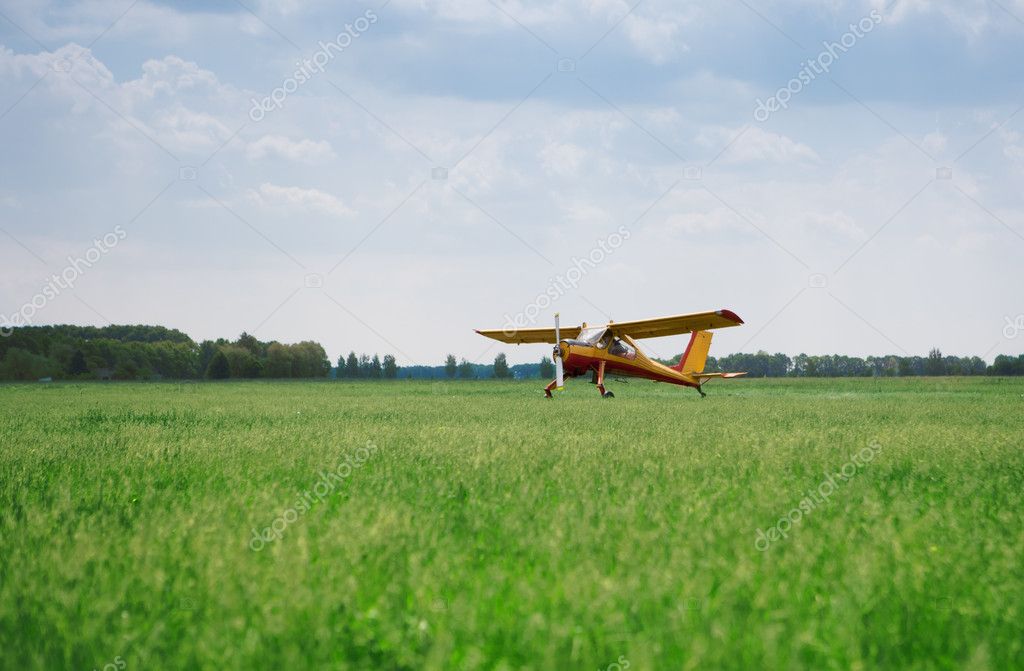 Little yellow airplane on field — Stock Photo © svyatoslavlipik #5133735