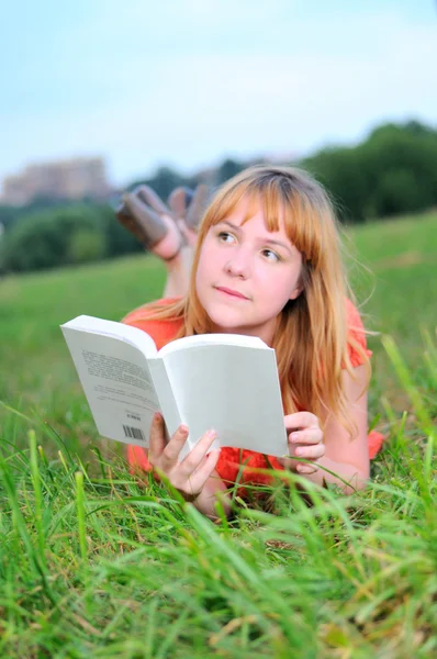Young smiling woman thinking with book in her hands — Stock Photo, Image