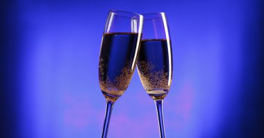 Flutes of champagne over blue background clipart