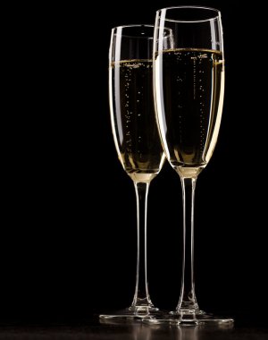 Two full glasses of champagne over dark background clipart