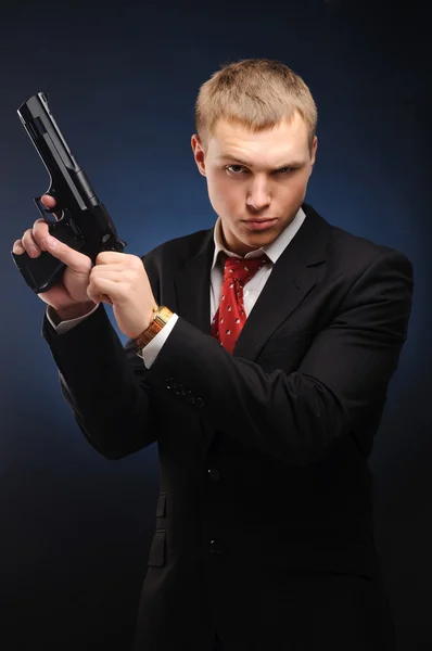 Junger Mann Mit Pistole Vor Dunklem Hintergrund — Stockfoto