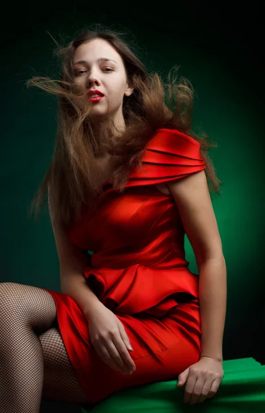 グリーン上の赤いドレスでファッショナブルな女性の肖像画 — ストック写真