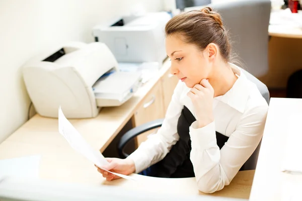 Beautiful woman reading docs in office — Stock Photo, Image