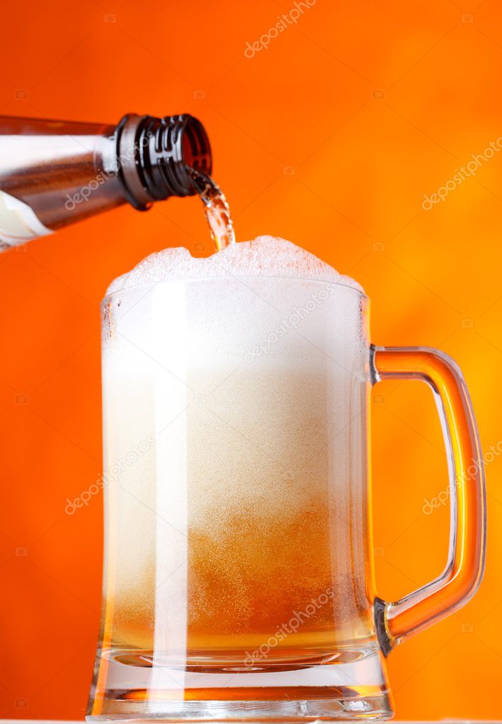 Pouring beer over orange background