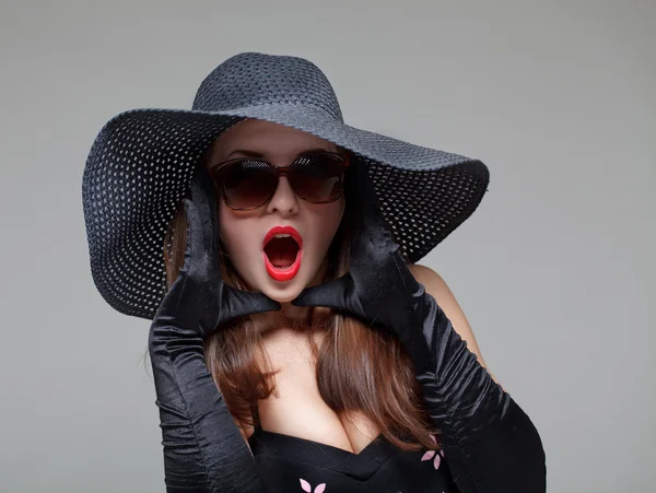 Молода жінка в чорному капелюсі і сонцезахисних окулярах — стокове фото