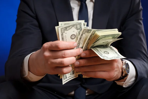Businessman counts money in hands. — Stock Photo, Image