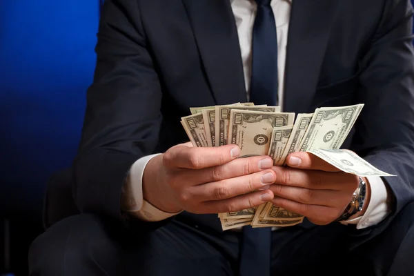 Empresário conta dinheiro nas mãos . — Fotografia de Stock