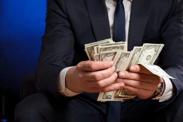 Businessman counts money in hands. — Stock Photo, Image