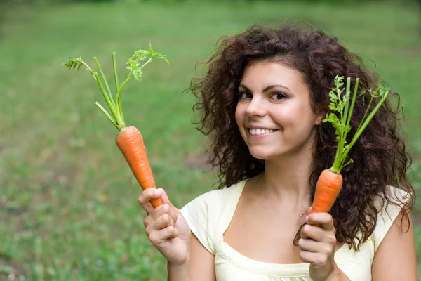 Mulher com par de cenouras frescas . — Fotografia de Stock