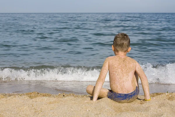 El chico se sienta en el agua — Foto de Stock
