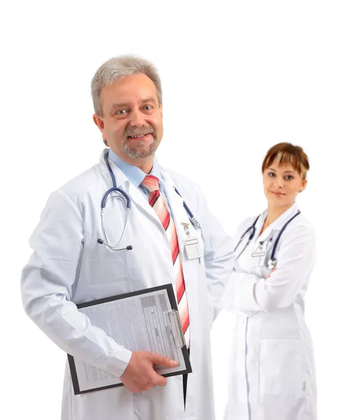 Happy smiling mature doctor writing on clipboard in a modern hospital — Stock Photo, Image