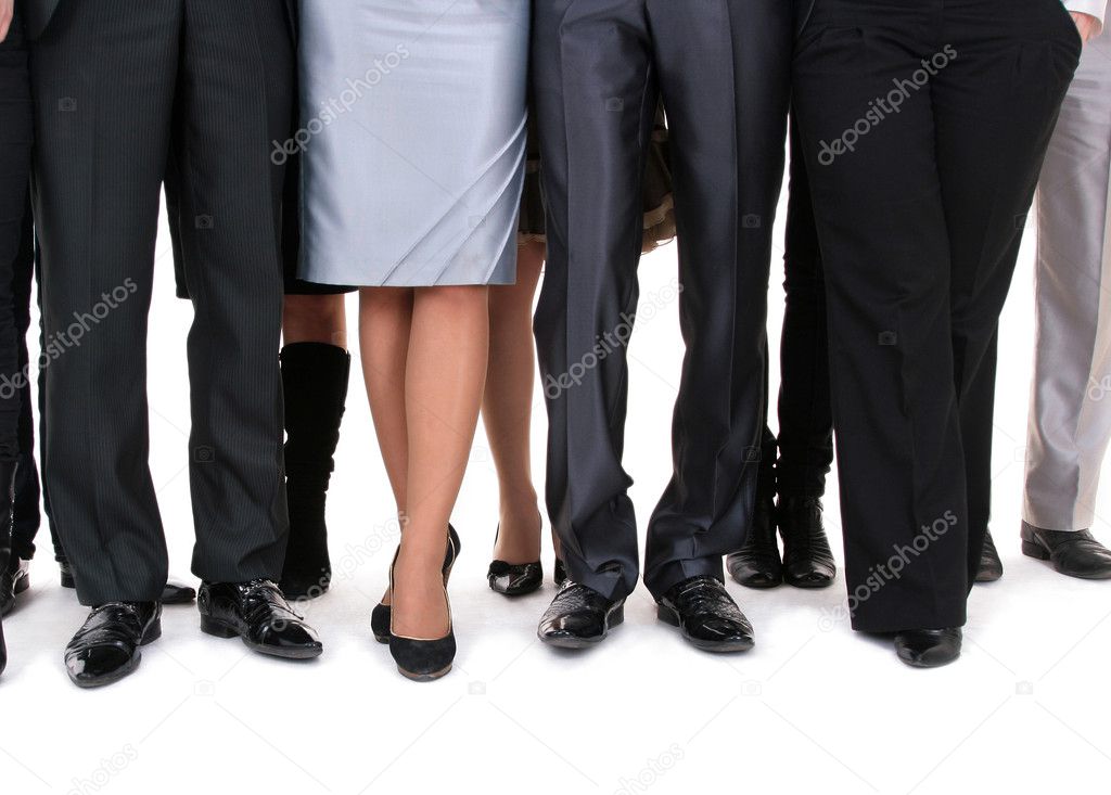 Many legs of a businesspeople sanding together.