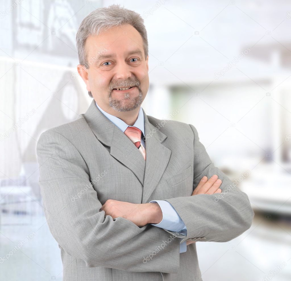 Mature successful businessman smiling and looking at camera