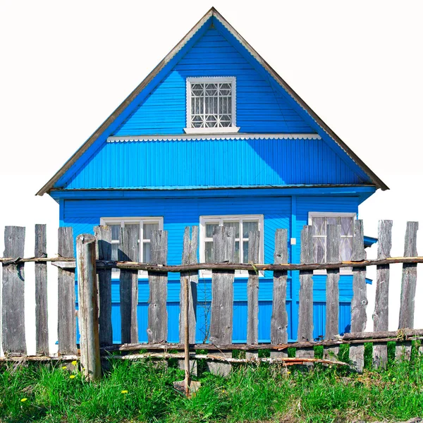 Старый деревянный забор против синего здания — стоковое фото