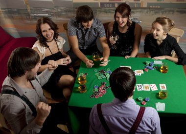 Group of young playing poker. clipart