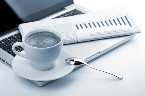 Filiżanka cappuccino z laptopem i gazetą — Zdjęcie stockowe