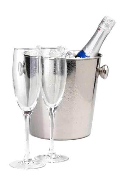 Champagne bottle in ice bucket and two empty glasses — Stock Photo, Image