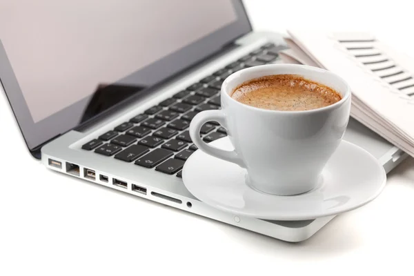 Varm cappuccino cup på laptop och tidningen — Stockfoto