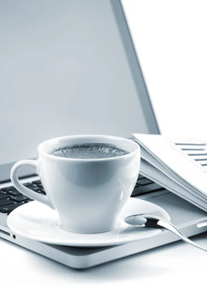 Hot cappuccino cup on laptop and newspaper — Stock Photo, Image