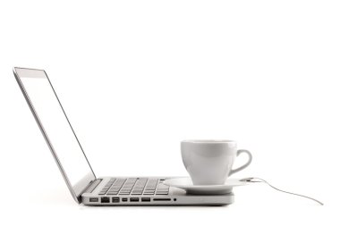 Cappuccino-kop met lepel op laptop