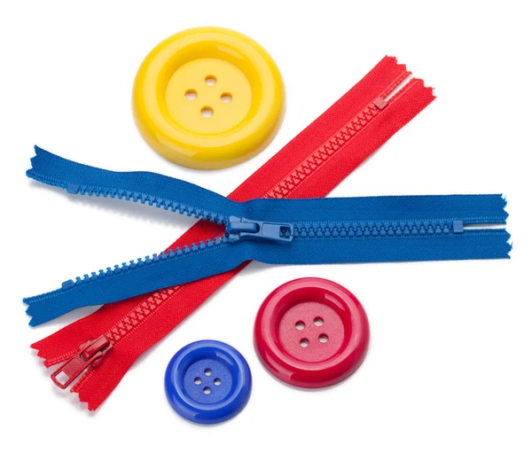 Three colored sewing buttons and two zippers — Stock Photo, Image