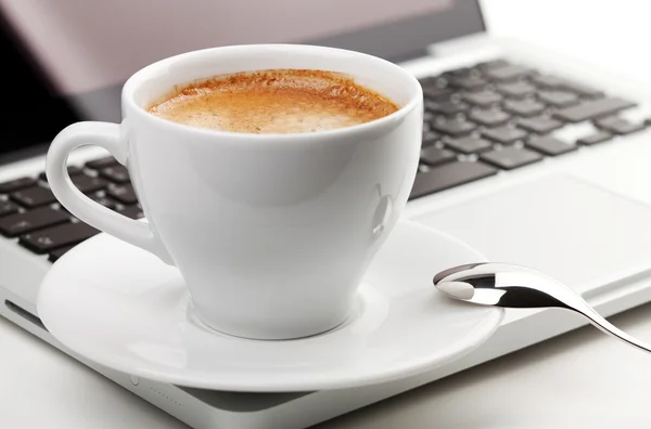 Cappuccino copo com colher no laptop — Fotografia de Stock