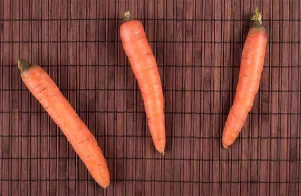 stock image Three carrots on a bamboo mat